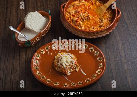 Autentico tinga di pollo messicano con formaggio fresco e panna sul pane tostato. Foto Stock
