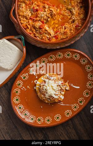 Autentico tinga di pollo messicano con formaggio fresco e panna sul pane tostato. Foto Stock