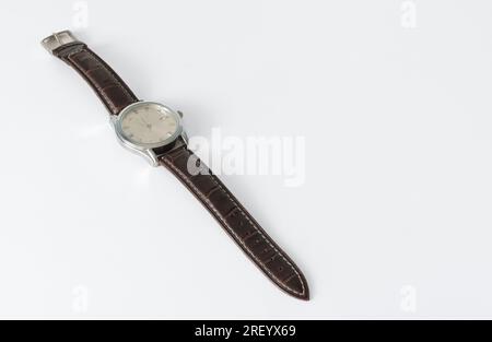 Orologio da polso dal vecchio stile con cinturino in pelle. Disposte diagonalmente su uno sfondo bianco isolato. posiziona per il testo Foto Stock