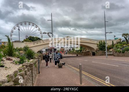 Regno Unito, Clacton 30 giugno 2023, ponte del molo di Clacton e ruota panoramica, persone che passano sotto il ponte Foto Stock