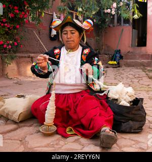 Llachon, Perù; 1 gennaio 2023: Una donna che lavora con la lana nella penisola di Llachon sul lago Titicaca. Foto Stock