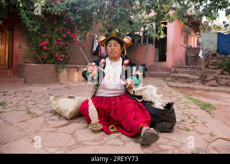 Llachon, Perù; 1 gennaio 2023: Una donna che lavora con la lana nella penisola di Llachon sul lago Titicaca. Foto Stock