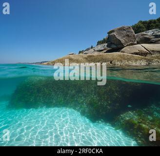 Massi sulla riva del mare, vista su e sotto la superficie dell'acqua, costa atlantica in Spagna, scenario naturale, Galizia, Rias Baixas Foto Stock
