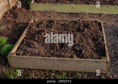 Aiuole rialzate in legno riempite di terreno. I letti sono vuoti e pronti per la semina. Foto Stock