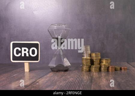 Testo CRO su white paper su sfondo chiaro con carta per grafici. Foto Stock