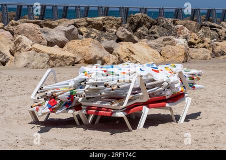 TEL AVIV, ISRAELE - 21 LUGLIO: Una pila di ombrelloni inutilizzati visti sulla spiaggia di Tel Baruch il 21 luglio 2023 a Tel Aviv, Israele. Foto Stock