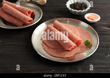 Salame di manzo affumicato, salsiccia sottile a fette su tavola di legno Foto Stock