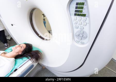 Il tecnico di scansione TC si affaccia sul paziente nello scanner di tomografia computerizzata durante la preparazione della procedura. Paziente donna che entra nello scanner TC. Foto Stock