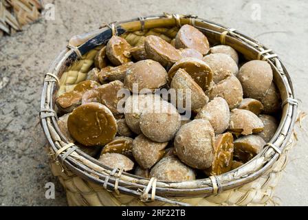 Un cesto pieno di zucchero di canna non raffinato Chillu Karuppatti, realizzato con linfa di palma e zenzero secco, famoso a Tiruchendur, Tamil Nadu, India meridionale Foto Stock