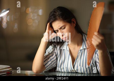 Donna stressata che respira a casa durante un colpo di calore di notte Foto Stock
