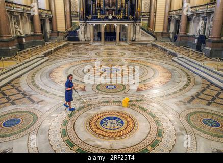 Louise Brewis pulisce il pavimento di Minton alla St George's Hall, Liverpool, prima che venga esposto al pubblico fino al 18 agosto. Il mosaico vittoriano, raramente visto a mano, di oltre 30.000 piastrelle Minton, fu posato nel 1852, ma coperto da un pavimento di legno negli anni '1860 per evitare danni da danze ed eventi. Data immagine: Lunedì 31 luglio 2023. Foto Stock