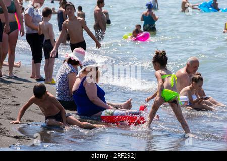 6 agosto 2022. Georgia. Villaggio Ureki. Spiaggia centrale con sabbia nera magnetica. La gente si rilassa sulla spiaggia affollata. Foto Stock