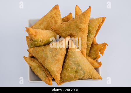 Chapati Mandazi Andazi Samosa spuntini triangolari su un piatto su sfondo bianco nella città di Nairobi, nella contea del Kenya, nell'Africa orientale. Cibo delizioso Foto Stock