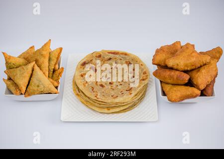 Chapati Mandazi Andazi Samosa spuntini triangolari su un piatto su sfondo bianco nella città di Nairobi, nella contea del Kenya, nell'Africa orientale. Cibo delizioso Foto Stock