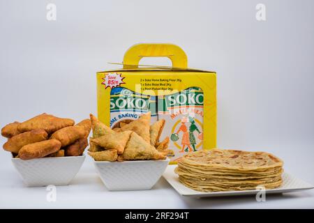 Chapati Mandazi Andazi Samosa spuntini triangolari su un piatto su sfondo bianco nella città di Nairobi, nella contea del Kenya, nell'Africa orientale. Cibo delizioso Foto Stock