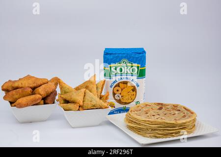 Chapati Mandazi Andazi Samosa spuntini triangolari su un piatto su sfondo bianco nella città di Nairobi, nella contea del Kenya, nell'Africa orientale. Cibo delizioso Foto Stock