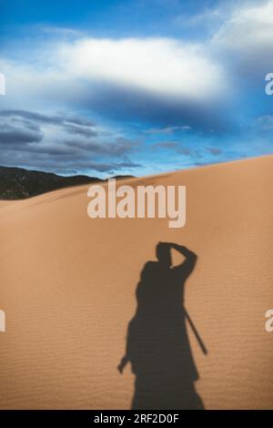 ombra del fotografo sulle grandi dune di sabbia del colorado al tramonto Foto Stock