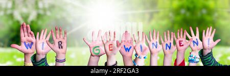 Children Hands Building Word Wir Gewinnen significa vincere, Grass Meadow Foto Stock