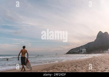 Giovane uomo che aspetta l'onda perfetta a Rio de Janeiro Foto Stock