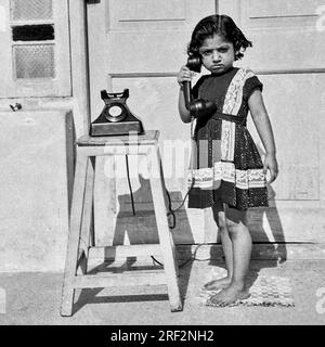 Vecchia immagine vintage anni '1900 in bianco e nero di una ragazza indiana, prima nera, nessun telefono senza quadrante, India 1940s Foto Stock
