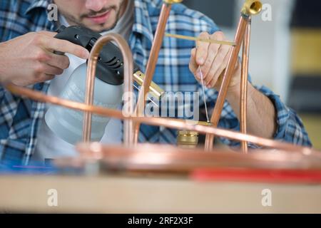 Plumber lavora con una torcia soffiante Foto Stock