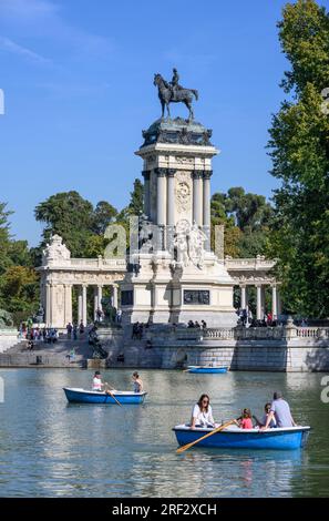 Guardando attraverso il lago nautico al Parco del Retiro verso il monumento a Re Alfonso XII, Madrid, Spagna Foto Stock