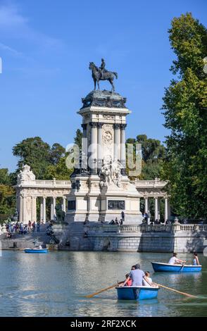 Guardando attraverso il lago nautico al Parco del Retiro verso il monumento a Re Alfonso XII, Madrid, Spagna Foto Stock