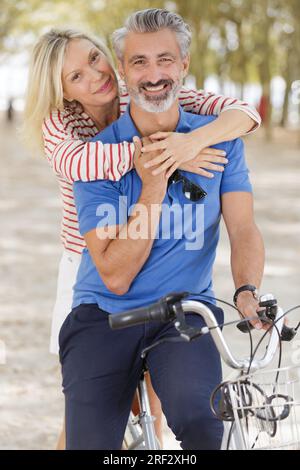 coppie mature attive in bicicletta durante le vacanze estive Foto Stock