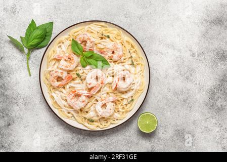 Spaghetti con scampi di gamberi su sfondo chiaro. Vista dall'alto, base piatta, spazio di copia. Cucina italiana e mediterranea. Foto Stock