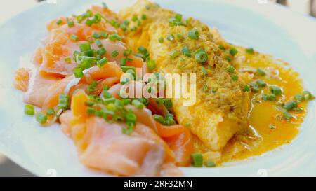 Uova strapazzate mescolate con salmone e verdure. Foto Stock