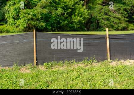 Tessuto Silt Fence con pali in legno installati prima dell'inizio della costruzione. Foto Stock