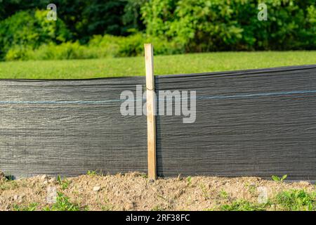 Tessuto Silt Fence con pali in legno installati prima dell'inizio della costruzione. Foto Stock