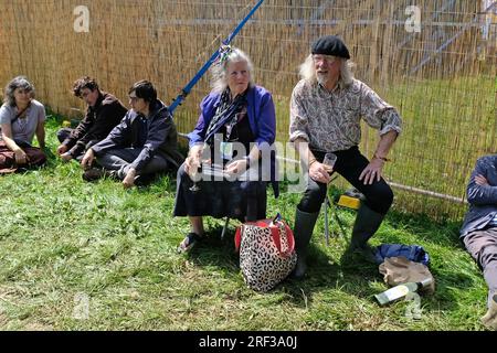 Persone sedute fuori da una tenda del festival ascoltando la musica ma non davanti agli altoparlanti. WOMAD 2023 Foto Stock