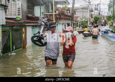 Provincia di Bulacan. 31 luglio 2023. I residenti trasportano i loro effetti personali mentre attraversano le acque alluvionali nella provincia di Bulacan, nelle Filippine, il 31 luglio 2023. Il bilancio delle vittime per inondazioni e frane innescate dal tifone Doksuri è salito a 25, con almeno 20 dispersi, l'agenzia nazionale delle Filippine per i disastri ha dichiarato lunedì. Crediti: Rouelle Umali/Xinhua/Alamy Live News Foto Stock