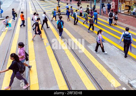 I pedoni che attraversano l'incrocio stradale in Eastern, Hong Kong, SAR, Cina Foto Stock