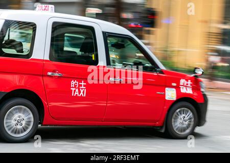 Toyota comfort Hybrid taxi in movimento, Wanchai, Hong Kong, sar, Cina Foto Stock