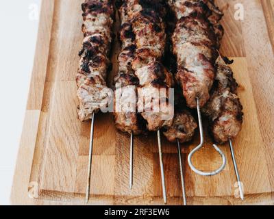 Kebab di maiale magro alla griglia con vista ravvicinata su un tagliere di legno Foto Stock