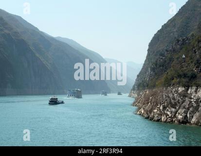 La nebbia paesaggio lungo il fiume Yangtze in Cina tra cui alcune navi e montagne Foto Stock