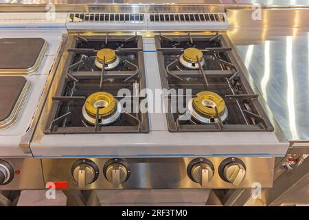 Grande piano cottura con bruciatore a gas nella cucina del ristorante commerciale Foto Stock