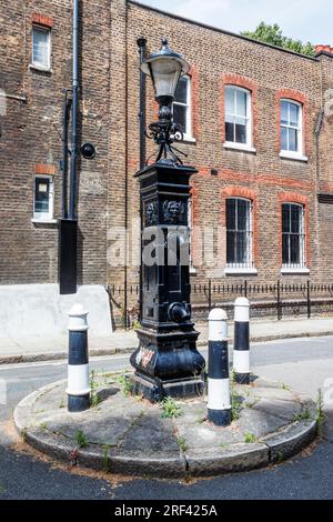 Una pompa dell'acqua pubblica georgiana di grado II a Bedford Row, Holborn, Londra, Regno Unito. Costruita nel 1826, la pompa è dotata di due beccucci Foto Stock