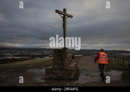 Vista della città con crocifisso sulla base sulla cima della scogliera costiera, a Workington, in Inghilterra, il 5 novembre 2019. Foto Stock