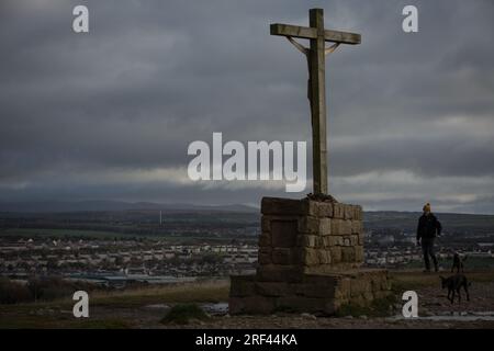 Vista della città con crocifisso sulla base sulla cima della scogliera costiera, a Workington, in Inghilterra, il 5 novembre 2019. Foto Stock