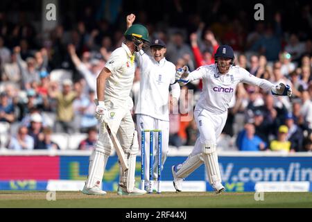 Jonny Bairstow (a destra) e Joe Root celebrano il wicket dell'australiano Pat Cummins (a sinistra), catturato da Ben Stokes (non nella foto) durante il quinto giorno del quinto test match della LV= Insurance Ashes Series al Kia Oval di Londra. Data immagine: Lunedì 31 luglio 2023. Foto Stock