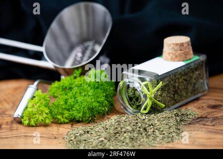 Prezzemolo verde fresco o prezzemolo secco e strofinato Petroselinum crispum Foto Stock