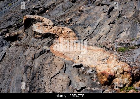 Contatto tra la diga di pegmatite e lo scisto. La Pegmatite è una roccia intrusiva ignea composta da quarzo, feldspato e mica. Lo scisto è una roccia metamorfica. Foto Stock