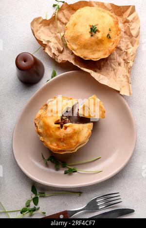 Piatto con gustose torte di carne su sfondo chiaro Foto Stock