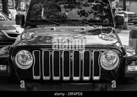 Vista frontale della Jeep wrangler nera parcheggiata in strada. Jeep Wrangler Sahara Black in una strada cittadina. Dettagli primi piani. Foto di strada, nessuno, selettivo Foto Stock