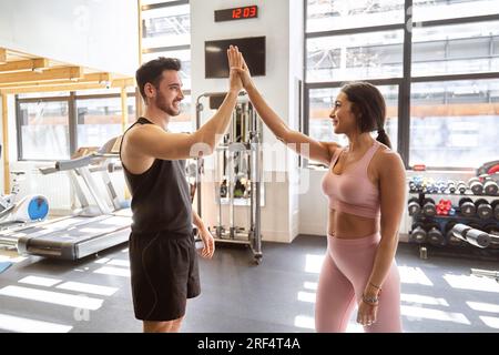 bruna coppia di fitness molto felice dopo aver finito il loro allenamento in palestra Foto Stock