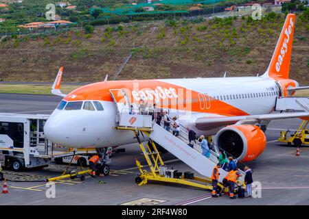 Viaggi aerei, aereo Easyjet, passeggeri in coda a bordo di un Easyjet Airbus A320-251N all'asfalto, Aeroporto dell'Isola di Madeira, Funchal, Portogallo Foto Stock