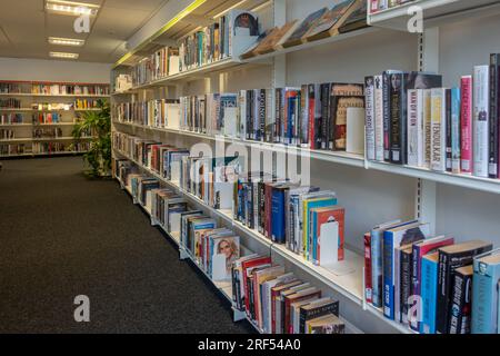 Interno della biblioteca locale della città di Farnborough con libri disponibili per il prestito sugli scaffali, Hampshire, Inghilterra, Regno Unito Foto Stock